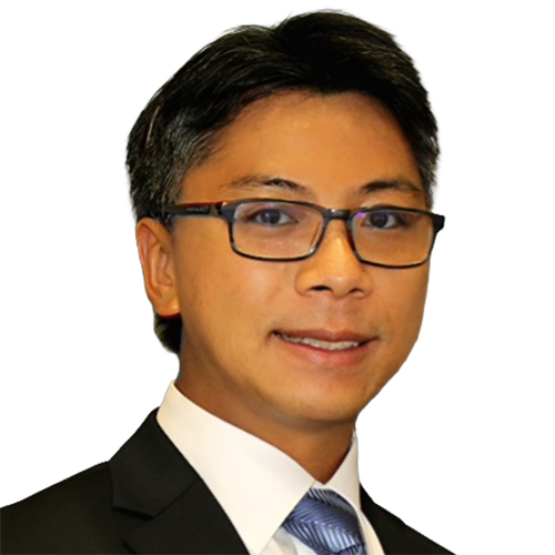 man with short dark hair, wearing glasses and a dark suit and tie